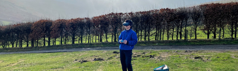 Person on a picnic blanket with goggles and remote control