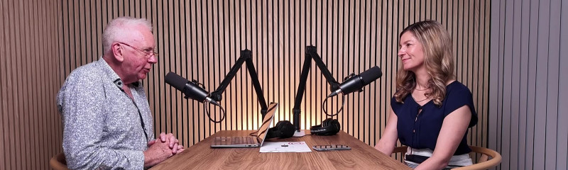 Two people in a podcast recording studio with mics