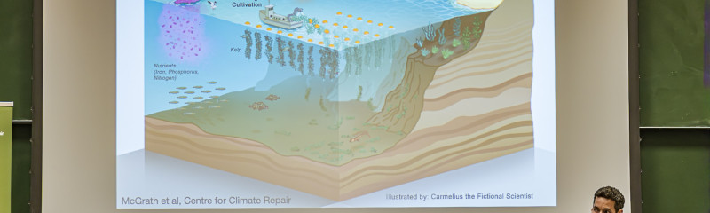 Person in front of a presentation showing an illustration of marine carbon dioxide removal