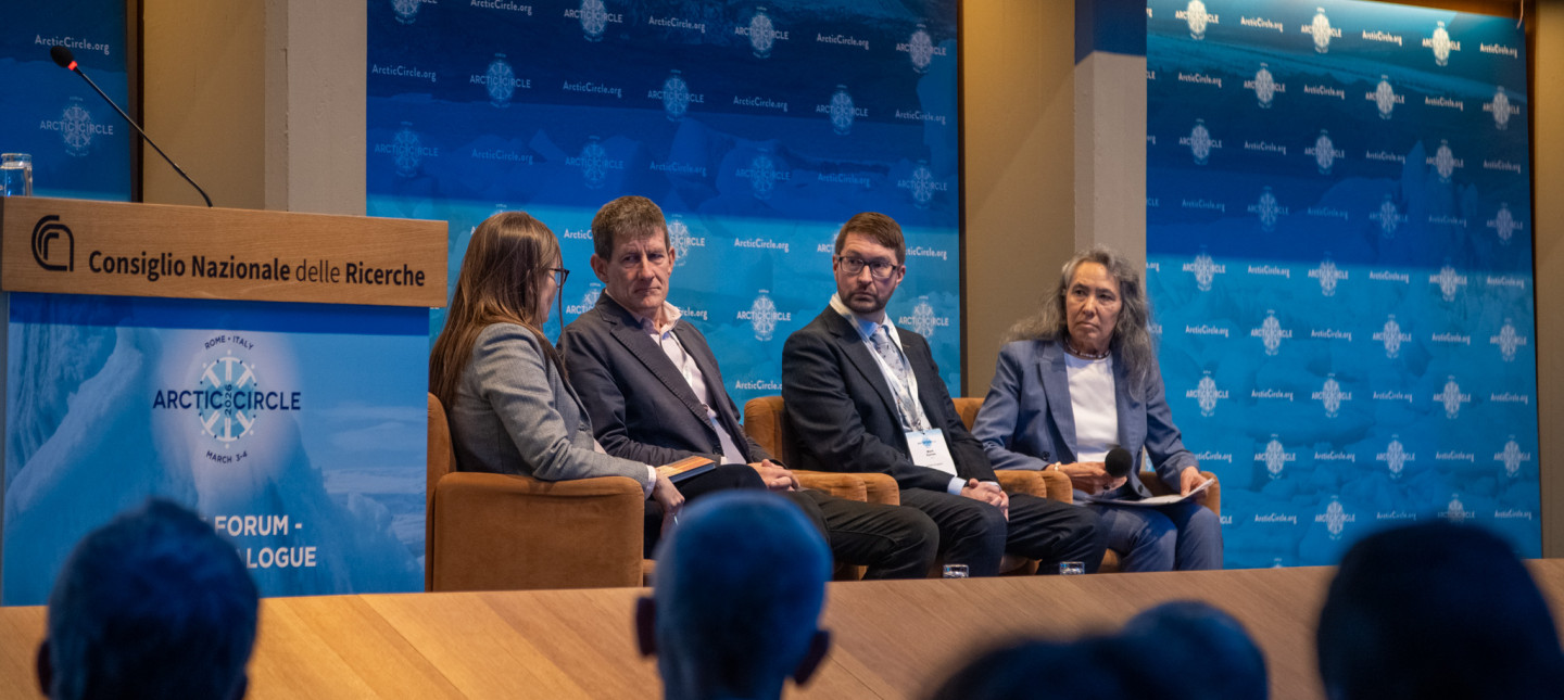 Panellists on chairs in front of audience