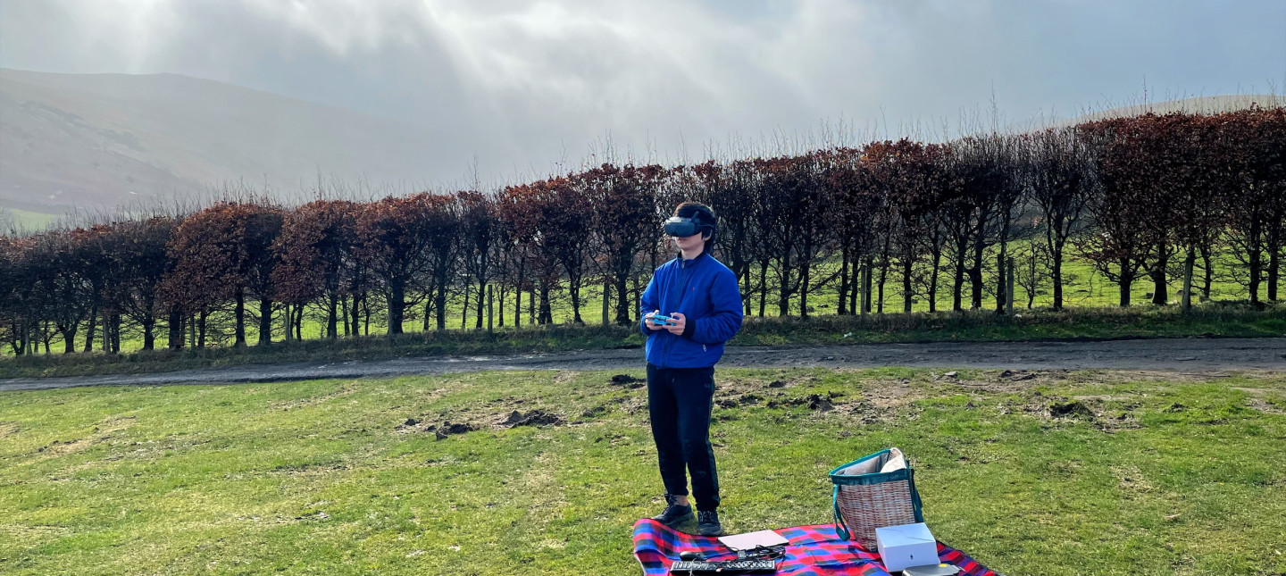 Person on a picnic blanket with goggles and remote control