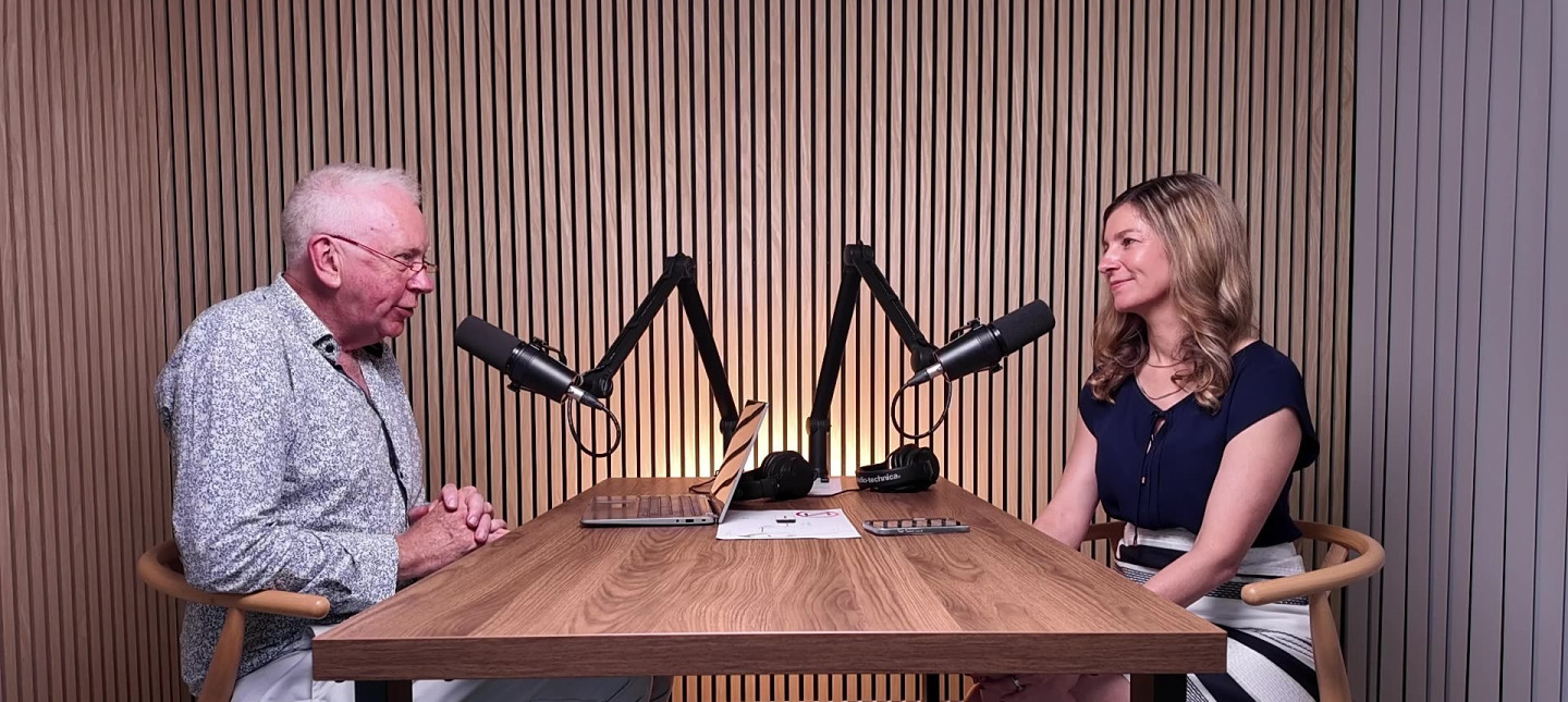 Two people in a podcast recording studio with mics