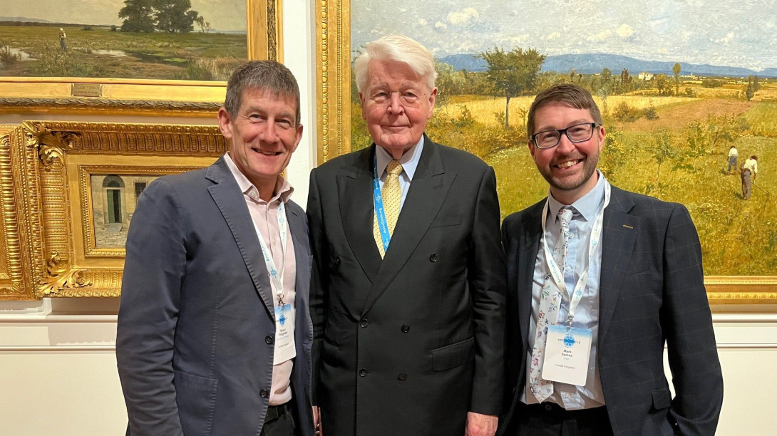 Three people in front of paintings